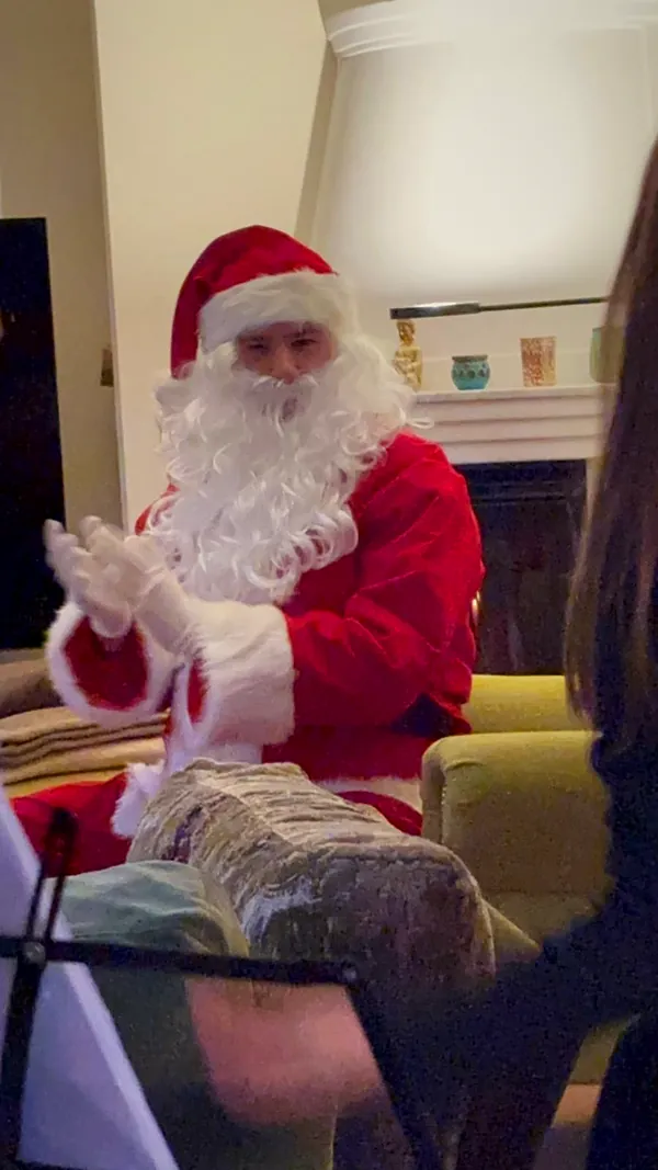 Der Weihnachtsmann klatscht bei einem Familienbesuch