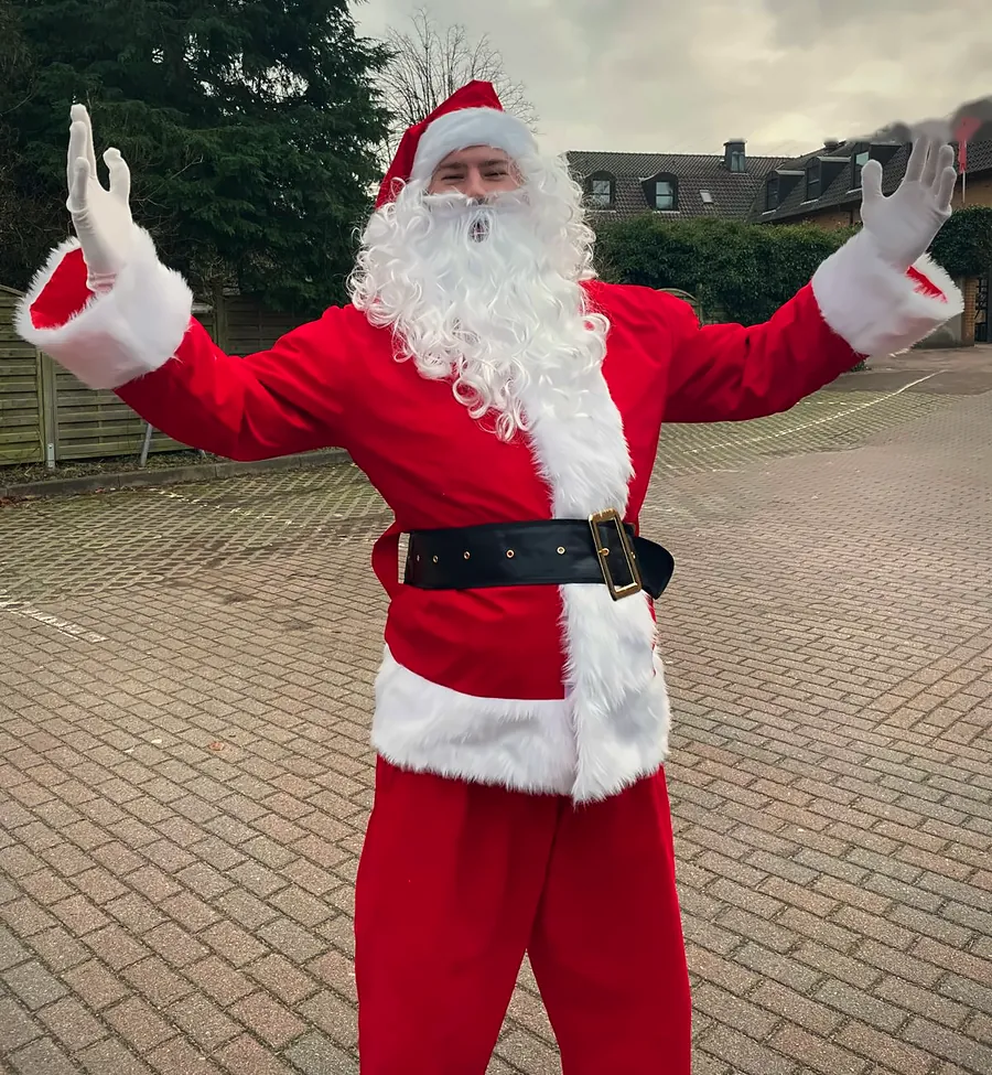 Unser Weihnachtsmann in Hamburg breitet zur Begrüßung die Arme aus